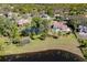 Stunning aerial view of a luxurious home with a pool, tennis court, and picturesque pond surrounded by lush greenery at 1477 Shadwell Cir, Lake Mary, FL 32746
