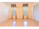 Bright bedroom with hardwood floors, large windows with elegant curtains, and closet with sliding doors at 1477 Shadwell Cir, Lake Mary, FL 32746