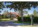 Charming home with brick driveway and lush landscaping, including mature trees, flowering plants, and manicured hedges at 1477 Shadwell Cir, Lake Mary, FL 32746