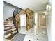 Grand foyer with a stone accent wall, a curved staircase, and patterned marble flooring at 1477 Shadwell Cir, Lake Mary, FL 32746