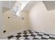 Functional laundry room with black and white checkered floor, utility connections, and a small diamond pane window at 1477 Shadwell Cir, Lake Mary, FL 32746
