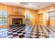 This charming living room is complete with a fireplace, checkered flooring and abundant natural light from large windows at 1477 Shadwell Cir, Lake Mary, FL 32746