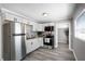 Updated kitchen features white cabinets, stainless steel appliances, and sleek gray floors at 1502 S Summerlin Ave, Sanford, FL 32771