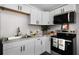 Modern kitchen features white cabinets and stainless steel appliances, granite countertops, and accent decor at 1502 S Summerlin Ave, Sanford, FL 32771
