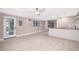 Open kitchen featuring stainless steel refrigerator, custom cabinets and light tile floors at 1505 Delaney Ave, Orlando, FL 32806