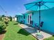Green backyard with an open patio featuring seating and vibrant, colorful umbrellas at 1618 Oregon Ave, St Cloud, FL 34769