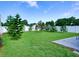 Manicured backyard with green grass, a privacy fence and a variety of trees at 1618 Oregon Ave, St Cloud, FL 34769