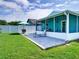 Backyard boasts a screened patio, lounge chairs and an umbrella with green grass at 1618 Oregon Ave, St Cloud, FL 34769
