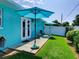Backyard with an open patio featuring two umbrellas, seating and green grass at 1618 Oregon Ave, St Cloud, FL 34769