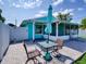 Backyard with an open patio, lounge chair and dining area with a colorful umbrella at 1618 Oregon Ave, St Cloud, FL 34769