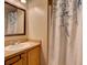 Cozy bathroom with decorative shower curtain, vanity with sink, and a framed mirror at 1618 Oregon Ave, St Cloud, FL 34769