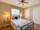 Well-lit bedroom with wood floors, floral bedding, and ample closet space at 1618 Oregon Ave, St Cloud, FL 34769
