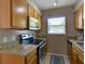 Well-lit kitchen featuring wood cabinets, granite countertops, and modern appliances at 1618 Oregon Ave, St Cloud, FL 34769