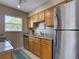 Kitchen with stainless steel refrigerator, light wood cabinets, and tile flooring at 1618 Oregon Ave, St Cloud, FL 34769