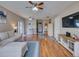 Open-concept living room with hardwood floors, modern furniture, and seamless transitions to other living spaces at 1618 Oregon Ave, St Cloud, FL 34769