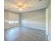 Bright bedroom with light gray walls, wood-look flooring, and large window with blinds at 16449 Cedar Crest Dr, Orlando, FL 32828