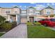 Charming townhome featuring a one-car garage, brick pathway, and well-maintained front lawn at 16449 Cedar Crest Dr, Orlando, FL 32828