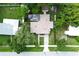 An aerial view of a home with an outdoor patio, a manicured yard, mature trees, and a long driveway at 1649 W Waycross Cir, Deltona, FL 32725