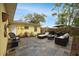 An outdoor patio with stone pavers, comfortable seating, a dining table, an umbrella, and a door to the home at 1649 W Waycross Cir, Deltona, FL 32725