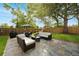 An outdoor patio with stone pavers, comfortable seating, a dining table, and an umbrella for shade at 1649 W Waycross Cir, Deltona, FL 32725