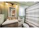 Well-lit green bathroom featuring tile, shower, and vanity with towels and supplies at 1649 W Waycross Cir, Deltona, FL 32725