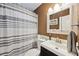 Bathroom with striped shower curtain, decorative mirror, and dark vanity at 1649 W Waycross Cir, Deltona, FL 32725