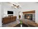 Open living room featuring a stone fireplace and TV area with neutral carpeting at 1649 W Waycross Cir, Deltona, FL 32725