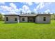 Spacious backyard showcasing the home's rear facade with multiple windows and a sliding glass door at 17477 Sw 41St Cir, Ocala, FL 34473