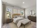 Relaxing bedroom with natural light, neutral tones, and a sitting bench at 17477 Sw 41St Cir, Ocala, FL 34473