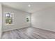 Bright, empty bedroom featuring wood-look floors and two windows at 17477 Sw 41St Cir, Ocala, FL 34473