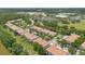 An aerial view of townhomes showing the community's layout and the surrounding wooded areas and retail buildings at 1852 Garden Sage Dr, Oviedo, FL 32765