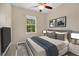 Cozy bedroom with a ceiling fan, large window with green tree view, and simple décor with neutral tones at 1852 Garden Sage Dr, Oviedo, FL 32765