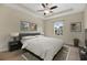 Serene bedroom featuring tray ceilings, a ceiling fan, a cozy bed, and natural light from the window at 1852 Garden Sage Dr, Oviedo, FL 32765
