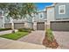 Townhouse exterior displaying gray stucco and stone accents, complemented by a brick driveway at 1852 Garden Sage Dr, Oviedo, FL 32765
