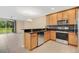 Kitchen with wood cabinets, granite countertops, stainless steel appliances, and backyard views at 1852 Garden Sage Dr, Oviedo, FL 32765