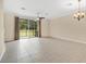 Living room showcasing neutral walls, tile flooring, sliding glass doors, and chandelier at 1852 Garden Sage Dr, Oviedo, FL 32765