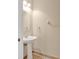 Stylish powder room with pedestal sink, round mirror, and ceramic tile flooring at 1852 Garden Sage Dr, Oviedo, FL 32765
