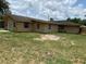 View of the backyard showcasing the house's exterior, lawn space, and fenced property line at 211 Valencia Rd, Debary, FL 32713