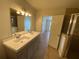 Bathroom with a double sink vanity, large mirror, shower and tile flooring at 211 Valencia Rd, Debary, FL 32713