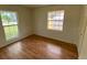 Bedroom featuring hardwood floors, two windows, and a closet at 211 Valencia Rd, Debary, FL 32713