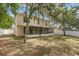 View of the backyard with mature trees, a white fence, grass, and an enclosed patio at 2255 Tealwood Cir, Tavares, FL 32778