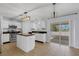 Well-lit kitchen featuring white cabinetry, island, stainless appliances, and outdoor access at 2255 Tealwood Cir, Tavares, FL 32778