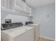 Laundry room featuring side-by-side washer and dryer, upper shelving, tile floors, and blue walls at 2255 Tealwood Cir, Tavares, FL 32778
