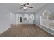 Open-concept living room with wood floors, arched doorways, and natural light from large windows at 2255 Tealwood Cir, Tavares, FL 32778