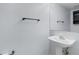 Powder room with a single white pedestal sink, brushed silver faucet, round mirror, and a towel rack at 2255 Tealwood Cir, Tavares, FL 32778