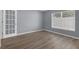 Room with a white french door, window with blinds, neutral paint, white trim, and laminate floors at 2255 Tealwood Cir, Tavares, FL 32778
