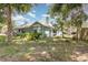 Exterior home view featuring a chimney, mature trees, and nice landscaping at 2283 Knollwood Dr, Leesburg, FL 34748
