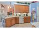 Bright kitchen featuring white appliances, wood cabinets, and tile backsplash at 2283 Knollwood Dr, Leesburg, FL 34748