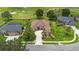 Aerial view of a luxury home on a golf course with lush landscaping, a paver driveway, and tile roof at 23538 Valderama Ln, Sorrento, FL 32776