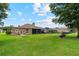 Expansive backyard featuring lush green grass, mature trees, outdoor seating, and a screened-in porch at 23538 Valderama Ln, Sorrento, FL 32776